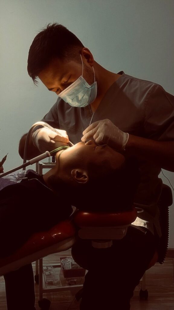 Dentist conducting a dental procedure on a patient in a clinic setting.